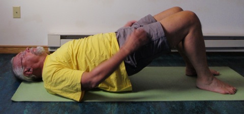Coach John Hughes demonstrating bridging exercise for core training for cycling
