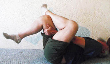 John Hughes demonstrating guteal stretch for cyclists